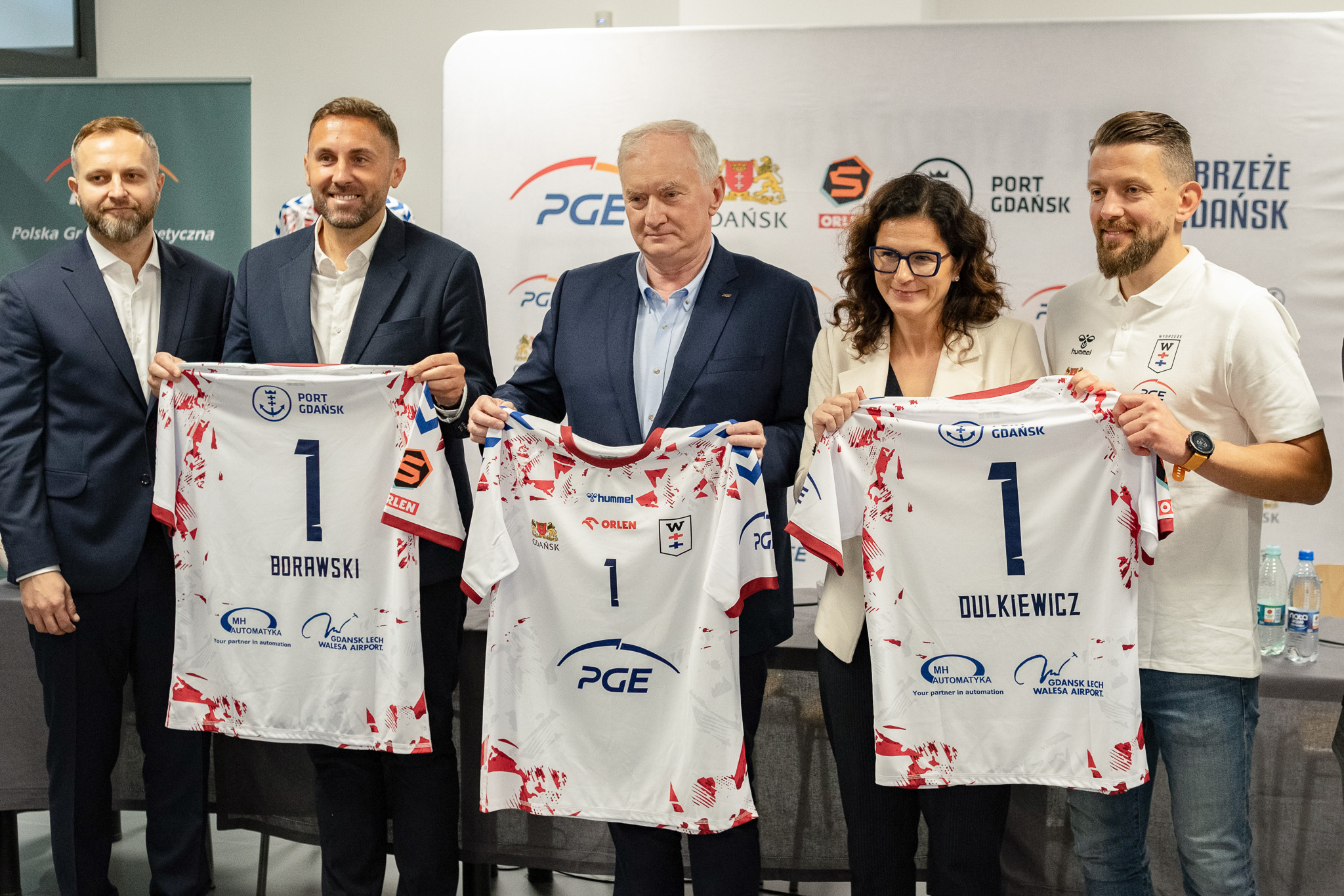 Zawodnicy drużyny piłki ręcznej Wybrzeże Gdańsk z koszulkami sponsora PGE.