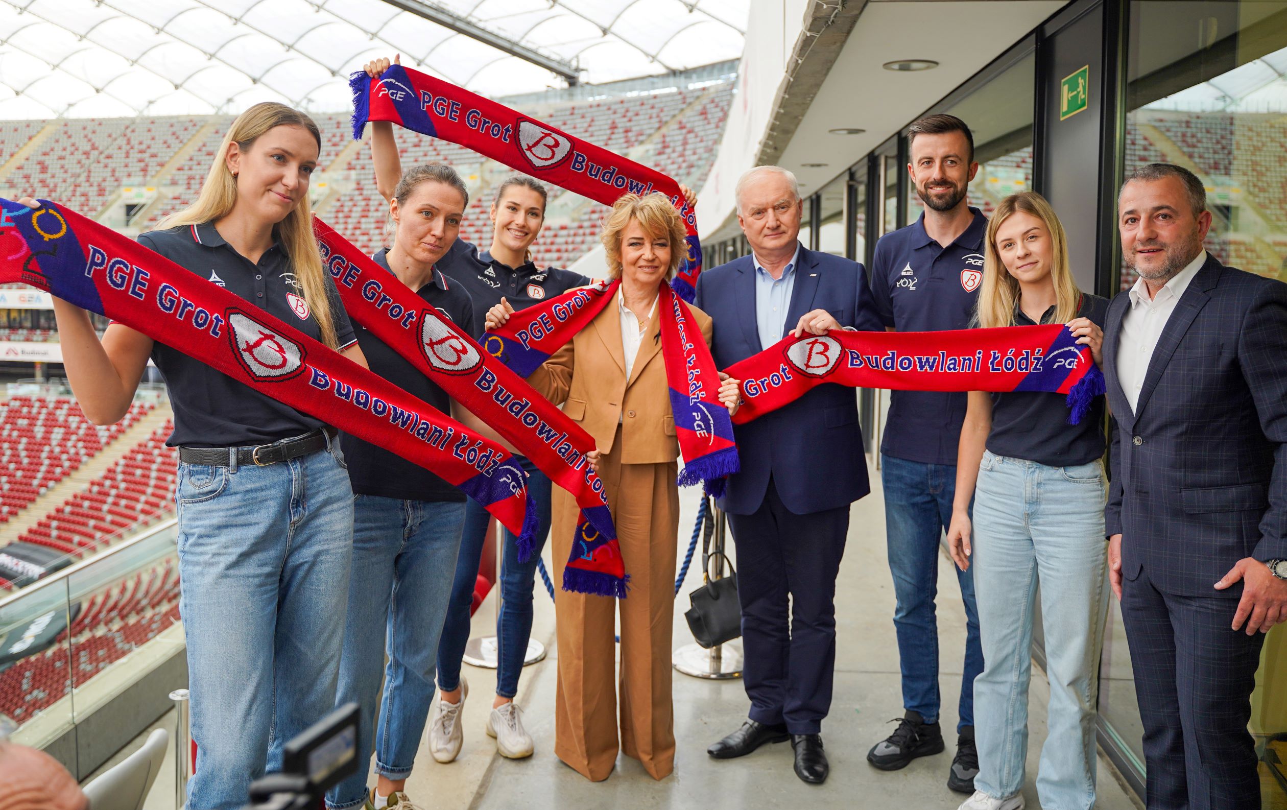 Grupa kibiców z szalikami drużyny sportowej Grot Budowlani Łódź sponsorowanej przez PGE na stadionie.