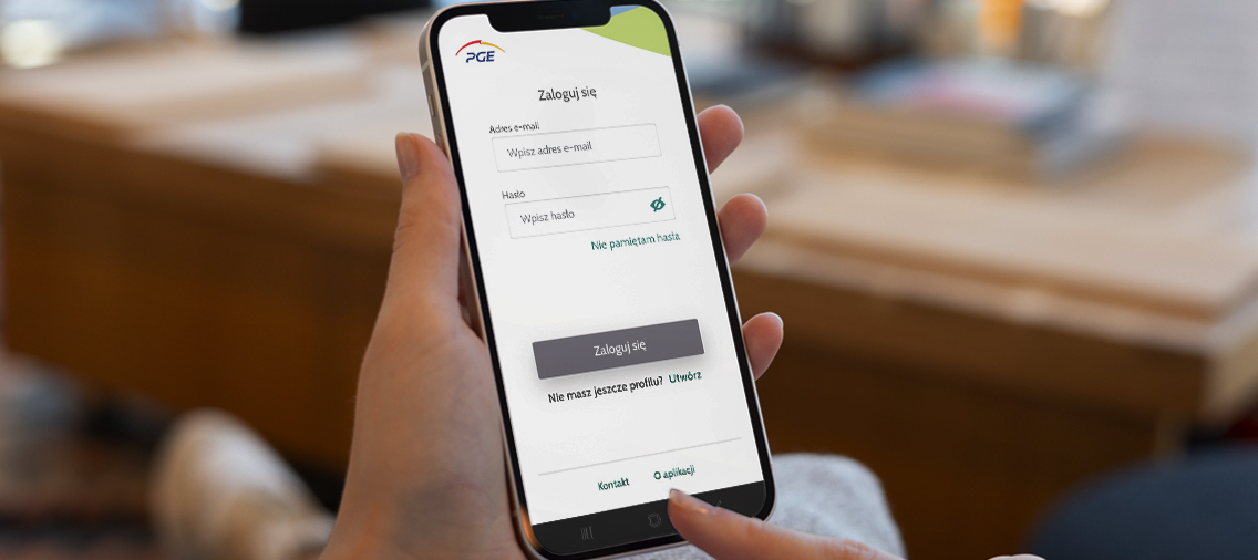 Zbliżenie na dłoń, która trzyma smartfon z uruchomioną aplikacją Moje PGE