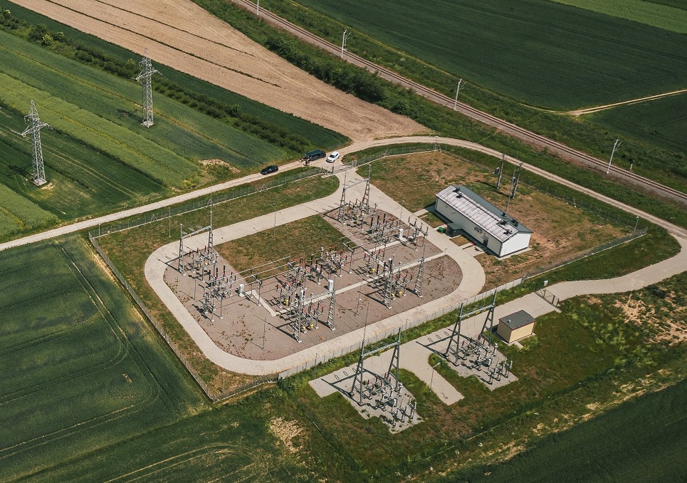 Rozdzielnia elektryczna z liniami energetycznymi pośrodku pól.